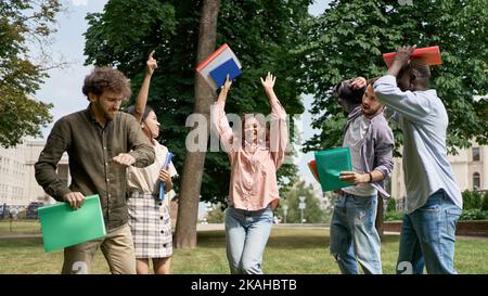 amis étudiants dansant sur l'herbe verte . Banque D'Images