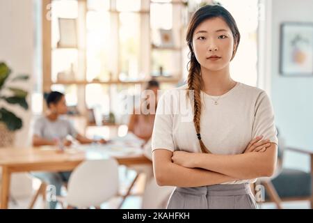 Portrait, leadership et rencontre avec une femme asiatique en affaires debout bras croisés dans une salle de conseil. Confiant, leader et planification avec un jeune Banque D'Images