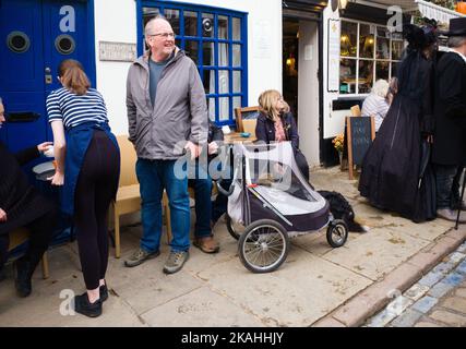 Café dans Church Street, Whitby pendant le week-end de goth occupé avec chien en poussette Banque D'Images