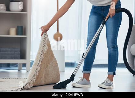 Femme, nettoyage et travail à la maison avec aspirateur appareil pour la moquette de salle de séjour pour nettoyer la saleté ou la poussière. Pieds de femme de ménage ou de femme au foyer Banque D'Images