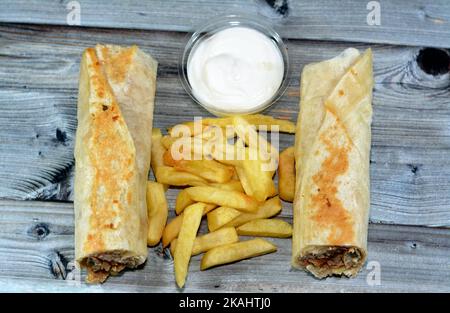 Recettes syriennes cuisine fond, poulet shawerma ou châtarma tortilla envelopper avec oignon, tomate, laitue et sauce à l'ail dans du pain syrien avec potatoe Banque D'Images