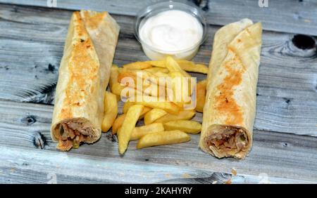 Recettes syriennes cuisine fond, poulet shawerma ou châtarma tortilla envelopper avec oignon, tomate, laitue et sauce à l'ail dans du pain syrien avec potatoe Banque D'Images