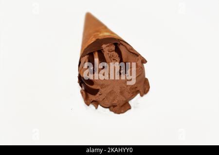 Boule de glace à la vanille au chocolat sur un cône biscuit avec sauce au chocolat isolée sur fond blanc, foyer sélectif de cône de glace brun foncé avec de l'esprit Banque D'Images