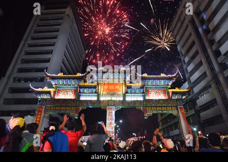 Les fêtards philippins filmeront la scène avec leur téléphone portable tandis que des feux d'artifice illuminent le ciel au-dessus de l'arche de l'amitié de Chinatown, la plus grande au monde, située dans le quartier de Binondo, à Manille, à la veille du nouvel an chinois, le 07 février 2016. Les citoyens philippins et chinois accueillent le nouvel an lunaire chinois qui tombe sur 08 février, qui marque le début de l'année du singe de feu. Banque D'Images