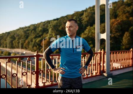 Le coureur mature respire dur prend une pause après le jogging Banque D'Images