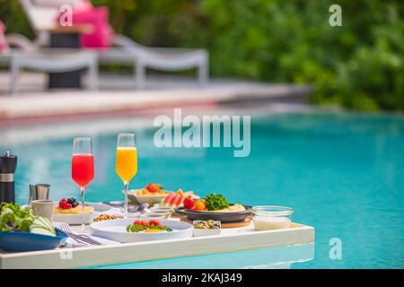 Plateau de petit déjeuner dans la piscine, petit déjeuner flottant dans un hôtel de luxe. Plage tropicale style de vie. Piscine du complexe, petit déjeuner flottant dans une ambiance luxueuse Banque D'Images