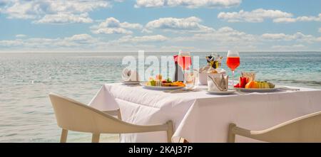 Table de petit déjeuner de luxe avec nourriture pour deux avec belle vue sur la mer tropicale. Vacances d'été le matin en couple et concept de vacances romantiques Banque D'Images