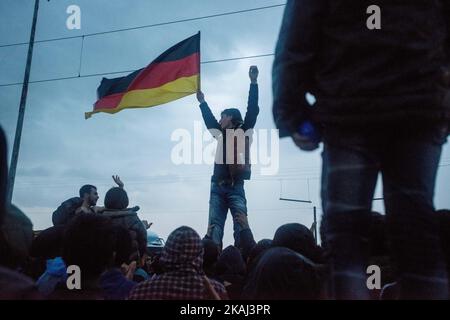 Les réfugiés brandisent le drapeau allemand alors qu'ils appellent à l'ouverture de frontières sur 12 mars 2016 à Idomeni, en Grèce. Les migrants sont bloqués dans le camp de réfugiés après que la Macédoine ait fermé sa frontière, alors que d'autres réfugiés continuent d'arriver dans le camp. (Photo de Guillaume Pinon/NurPhoto) *** Veuillez utiliser le crédit du champ de crédit *** Banque D'Images