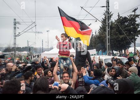 Les réfugiés brandisent le drapeau allemand alors qu'ils appellent à l'ouverture de frontières sur 12 mars 2016 à Idomeni, en Grèce. Les migrants sont bloqués dans le camp de réfugiés après que la Macédoine ait fermé sa frontière, alors que d'autres réfugiés continuent d'arriver dans le camp. (Photo de Guillaume Pinon/NurPhoto) *** Veuillez utiliser le crédit du champ de crédit *** Banque D'Images