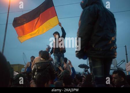 Les réfugiés brandisent le drapeau allemand alors qu'ils appellent à l'ouverture de frontières sur 12 mars 2016 à Idomeni, en Grèce. Les migrants sont bloqués dans le camp de réfugiés après que la Macédoine ait fermé sa frontière, alors que d'autres réfugiés continuent d'arriver dans le camp. (Photo de Guillaume Pinon/NurPhoto) *** Veuillez utiliser le crédit du champ de crédit *** Banque D'Images