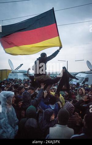 Les réfugiés brandisent le drapeau allemand alors qu'ils appellent à l'ouverture de frontières sur 12 mars 2016 à Idomeni, en Grèce. Les migrants sont bloqués dans le camp de réfugiés après que la Macédoine ait fermé sa frontière, alors que d'autres réfugiés continuent d'arriver dans le camp. (Photo de Guillaume Pinon/NurPhoto) *** Veuillez utiliser le crédit du champ de crédit *** Banque D'Images