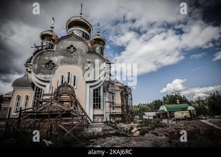 Travaille dans la nouvelle église de Slavutich, en Ukraine, ville des travailleurs relocalisés après l'accident de la centrale nucléaire de Tchernobyl. Dans le côté droit, la vieille église, sur 25 août 2014. La catastrophe de Tchernobyl a été un accident nucléaire catastrophique qui s'est produit le 26 avril 1986 à la centrale nucléaire de Tchernobyl, dans la ville de Pripyat, en Ukraine (alors officiellement la RSS d'Ukraine), qui était sous la juridiction directe des autorités centrales de l'Union soviétique. Une explosion et un incendie ont libéré de grandes quantités de particules radioactives dans l'atmosphère, qui se sont répandues sur une grande partie de l'wester Banque D'Images