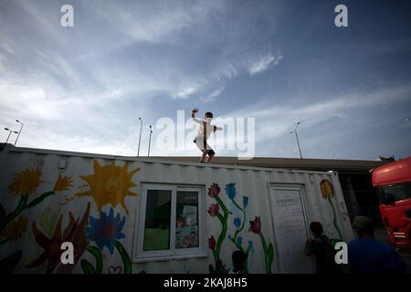 Un enfant au-dessus d'un conteneur. Réfugiés et migrants bloqués dans le port du Pirée à Athènes, Grèce, 11 mai 2016. Environ 2,000 personnes restent au port dans des tentes, un entrepôt et un terminal. Plus de 3,000 personnes ont été déplacées du port vers des camps gouvernementaux. (Photo de Giorgos Georgiou/NurPhoto) *** Veuillez utiliser le crédit du champ de crédit *** Banque D'Images