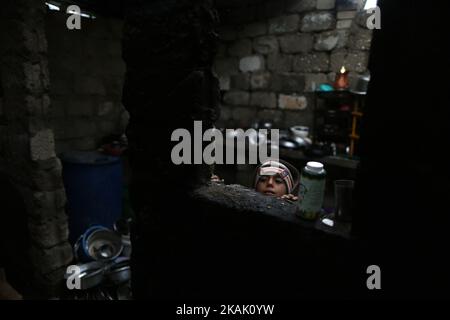 Un garçon palestinien regarde dans les bidonvilles de Charm fleuris à la périphérie du camp de réfugiés de Khan Younis, dans le sud de la bande de Gaza sur 14 décembre 2016 et l'expansion des taudis fleurs de Charm, où les enfants jouent pieds nus dans la voiture abandonnée rouillée et entourée de montagnes de structures d'ordures, Est un signe de vie à Gaza, où la pauvreté augmente et où il n'y a pas d'espoir pour l'avenir. Bien que Gaza ait toujours été pauvre, la situation a empiré de 1,8 millions de personnes qui vivent dans la région côtière surpeuplée depuis la prise de pouvoir du Hamas en 2007. (Photo de Majdi Fathi/NurPhoto) *** Veuillez utiliser le crédit du champ de crédit Banque D'Images