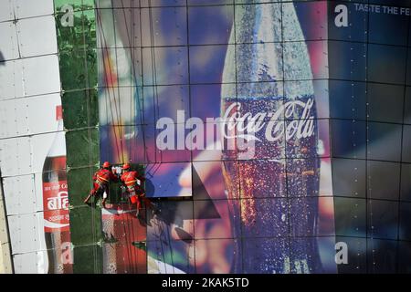 Les travailleurs népalais apposant un autocollant publicitaire sur le miroir du bâtiment de l'UWTC, Katmandou, Népal, mardi, 03 janvier 2016. (Photo de Narayan Maharajan/NurPhoto) *** Veuillez utiliser le crédit du champ de crédit *** Banque D'Images