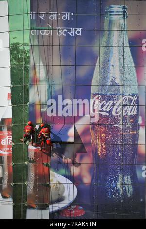 Les travailleurs népalais apposant un autocollant publicitaire sur le miroir du bâtiment de l'UWTC, Katmandou, Népal, mardi, 03 janvier 2016. (Photo de Narayan Maharajan/NurPhoto) *** Veuillez utiliser le crédit du champ de crédit *** Banque D'Images