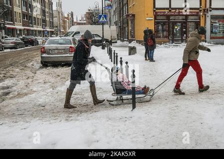 Des personnes avec un enfant sur le traîneau sont vues. De fortes chutes de neige et des gelées frappent la ville de Gdansk, dans le nord de la Pologne, le 6 janvier 2017. Basse température proche de moins 10 degrés Celsius et la neige paralyse la circulation routière dans la région. (Photo de Michal Fludra/NurPhoto) *** Veuillez utiliser le crédit du champ de crédit *** Banque D'Images