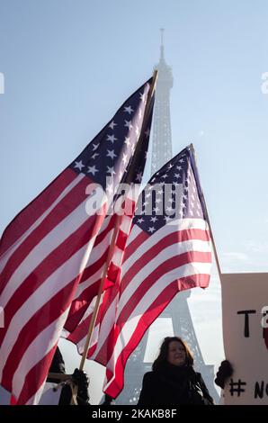 Un manifestant porte un drapeau américain lors d'un rassemblement de solidarité avec les partisans de la Marche des femmes à Washington et de nombreuses autres villes à 21 janvier 2017, devant la Tour Eiffel à Paris, un jour après l'investiture du président américain Donald Trump. Des rassemblements de protestation ont eu lieu dans plus de 30 pays à travers le monde en solidarité avec la marche des femmes de Washington pour la défense de la liberté de la presse, des femmes et des droits de l'homme après l'inauguration officielle de Donald J Trump en tant que Président des États-Unis d'Amérique en 45th. (Photo de Julien Mattia/NurPhoto) *** Veuillez utiliser crédit fro Banque D'Images