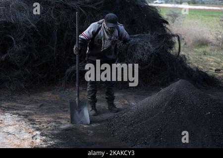 Un palestinien Ashraf Hillis travaille à la production d'un pigment noir destiné à être utilisé dans les matériaux de construction par la combustion de pneus de véhicules, dans la zone tampon à l'est de la ville de Gaza, le 25 janvier 2017. (Photo de Majdi Fathi/NurPhoto) *** Veuillez utiliser le crédit du champ de crédit *** Banque D'Images