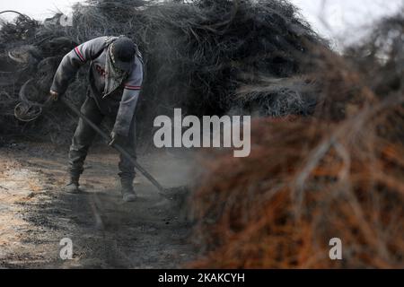 Un palestinien Ashraf Hillis travaille à la production d'un pigment noir destiné à être utilisé dans les matériaux de construction par la combustion de pneus de véhicules, dans la zone tampon à l'est de la ville de Gaza, le 25 janvier 2017. (Photo de Majdi Fathi/NurPhoto) *** Veuillez utiliser le crédit du champ de crédit *** Banque D'Images