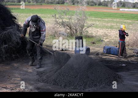 Un palestinien Ashraf Hillis travaille à la production d'un pigment noir destiné à être utilisé dans les matériaux de construction par la combustion de pneus de véhicules, dans la zone tampon à l'est de la ville de Gaza, le 25 janvier 2017. (Photo de Majdi Fathi/NurPhoto) *** Veuillez utiliser le crédit du champ de crédit *** Banque D'Images