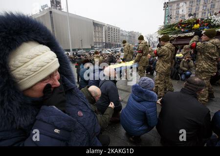 Les camarades portent des cercueils avec les corps des soldats ukrainiens tandis que les gens s'agenouillent pour rendre leur respect lors d'une cérémonie funéraire pour sept militaires tués dans le conflit de l'est de l'Ukraine près de la ville d'Avdiivka, sur la place de l'indépendance à Kiev, en Ukraine, le 01 février 2017. Des tirs d'artillerie lourde et de roquettes ont frappé les zones résidentielles et industrielles autour d'Avdiivka, dans le cadre d'une nouvelle explosion de combats entre les troupes gouvernementales et les rebelles séparatistes soutenus par la Russie. Au moins huit personnes ont été tuées et des dizaines blessées dans les combats. (Photo de Maxym Marusenko/NurPhoto) *** Veuillez utiliser Credit fro Banque D'Images