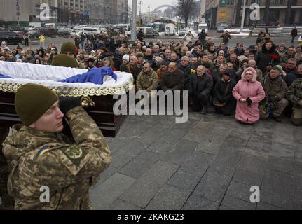 Les camarades portent des cercueils avec les corps des soldats ukrainiens tandis que les gens s'agenouillent pour rendre leur respect lors d'une cérémonie funéraire pour sept militaires tués dans le conflit de l'est de l'Ukraine près de la ville d'Avdiivka, sur la place de l'indépendance à Kiev, en Ukraine, le 01 février 2017. Des tirs d'artillerie lourde et de roquettes ont frappé les zones résidentielles et industrielles autour d'Avdiivka, dans le cadre d'une nouvelle explosion de combats entre les troupes gouvernementales et les rebelles séparatistes soutenus par la Russie. Au moins huit personnes ont été tuées et des dizaines blessées dans les combats. (Photo de Maxym Marusenko/NurPhoto) *** Veuillez utiliser Credit fro Banque D'Images