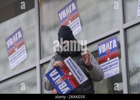 Les membres du 'National corps' coller les plaques qui dit 'attention! C'est la banque de pays agresseur! Il sera fermé. Retirez votre argent immédiatement ! » sur le mur. Les activistes du bataillon nationaliste Azov, aile politique 'corps national', picket le bureau de la banque russe Sberbank à Kiev, le 2 février 2017. (Photo par Sergii Kharchenko/NurPhoto) *** Veuillez utiliser le crédit du champ de crédit *** Banque D'Images