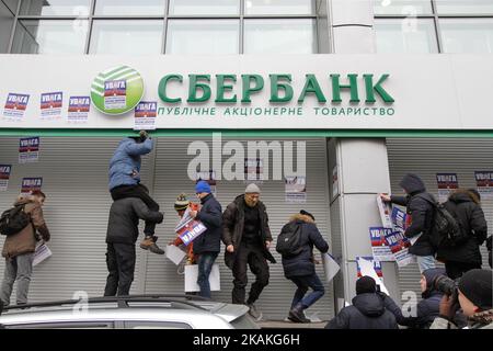 Les membres du 'National corps' coller les plaques qui dit 'attention! C'est la banque de pays agresseur! Il sera fermé. Retirez votre argent immédiatement ! » sur le mur. Les activistes du bataillon nationaliste Azov, aile politique 'corps national', picket le bureau de la banque russe Sberbank à Kiev, le 2 février 2017. (Photo par Sergii Kharchenko/NurPhoto) *** Veuillez utiliser le crédit du champ de crédit *** Banque D'Images