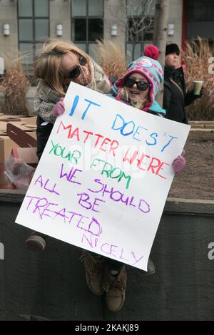 Mère et fille tenant un signe alors que des milliers de Canadiens participent à une protestation massive contre l'interdiction de voyager du président Trump contre les musulmans pendant la Journée nationale d'action contre l'islamophobie et la suprématie blanche dans le centre-ville de Toronto, Ontario, Canada, on 04 février 2017. Les Canadiens se sont joints à des pays du monde entier pour protester contre l'ordre exécutif du président américain Donald Trump, interdisant les citoyens de sept pays musulmans à majorité (Iran, Irak, Soudan, Somalie, Syrie, Yémen et Libye) d'entrer aux États-Unis pour les trois prochains mois et d'interdire indéfiniment aux réfugiés syriens Banque D'Images