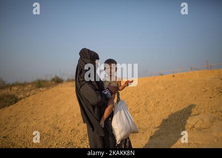 Une mère réfugiée de Rohingya tient son enfant dans le camp de réfugiés de Kutupalong, Cox's Bazar, au Bangladesh. 7 février 2017. Après les attaques des militants Rohingya sur des postes de police frontaliers à 9 octobre 2016, l'armée birmane a entrepris une série d'« opérations de dédouanement » dans le nord de l'État de Rakhine. Les forces de sécurité ont exécuté sommairement des hommes, des femmes et des enfants, pillé des biens et incendié au moins 1 500 maisons et autres bâtiments. Plus de 69 000 Rohingya se sont enfuis au Bangladesh. Actuellement, le nombre est d'environ 70 000. (Photo de Turjoy Chowdhury/NurPhoto) *** Veuillez utiliser le crédit du champ de crédit *** Banque D'Images