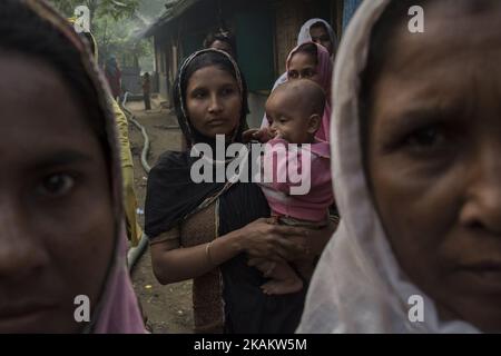 Un groupe de femmes Rohingya marchant vers un avenir incertain. Kutupalong, Bangladesh, 21.02.17 . Les réfugiés musulmans Rohingya du Bangladesh sont à l'origine des habitants de la province d'Arakan au Myanmar. Toutefois, lorsque la citoyenneté du Myanmar a été refusée en 1990s et que la torture par les forces militaires et les forces extrémistes bouddhistes a augmenté, la communauté a été forcée de se réfugier dans les camps de fortune du Bangladesh. Plus d'un million de Rohingyas vivent aujourd'hui sans commodités de base dans les camps gouvernementaux comme Kutupalong. L'avenir est tout aussi difficile que le gouvernement du Bangladesh envisage de relocaliser la population Banque D'Images