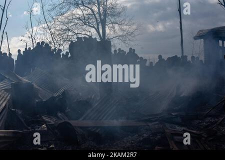 Les musulmans cachemiriens regardent vers les débris de la guerre ravagés maison résidentielle après une bataille à coups d'armes entre les forces gouvernementales indiennes et les rebelles cachemiriens sur 09 mars 2017 à Padgampauvres, à 30 kilomètres (18 miles) au sud de Srinagar, la capitale estivale du Cachemire administré par l'Inde, en Inde. Deux civils, dont un adolescent, ont été tués lors d'affrontements avec les forces gouvernementales indiennes lorsqu'ils ont essayé de sauver les rebelles locaux engagés dans une bataille d'armes à feu avec les forces les rebelles ont également été tués dans la bataille d'armes à feu plus tard dans la journée, Dans le district de Pulwom, au sud du Cachemire. (Photo de Yawar Nahir/ Nur photo) *** Banque D'Images