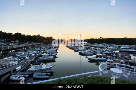 Un port de plaisance sur une nuit d'été plein de bateaux et le soleil presque fait le décor dans le fond. Banque D'Images