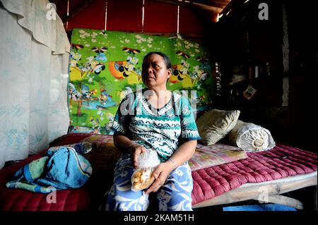 Nurtinah prend une pause après avoir travaillé comme un Trésor dans sa petite hutte. Nurtinah, 47 ans, une travailleuse agricole du village de Pucang anom, dans le sous-district de Cerme, dans le district de Bondowoso, dans la province de Java-est, en Indonésie, rêvait de gagner plus dans la ville. Elle a quitté son mari pour travailler comme éliminateur à Surabaya en 2012. Son amie Nurul lui a demandé de travailler comme éliminateur dans la décharge de Keputih avec un revenu d'environ 2,5 millions de RP par mois. Elle vit dans une petite hutte de 2x3 mètres, fabriquée à partir de carton, de contreplaqué, de zinc et de plastique usagés, près de la décharge. Elle travaille de 5 h à 5 h tous les jours, triant les ordures qui peuvent être re Banque D'Images