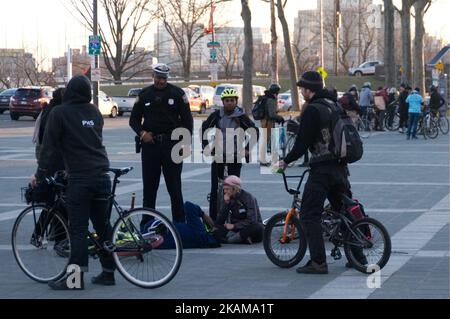 Avant l'arrivée de l'EMS, des spectateurs sont vus s'occuper d'un jeune cycliste qui est tombé au sol après avoir exécuté une « Wheelie » au musée d'art Steps, à Philadelphie, en Pennsylvanie, avant une promenade de protestation de 17 février 2017 en grève de vélo au départ de cet endroit. Les adolescents en VTT sont décrits comme des « Wheelie Kids » et sont un phénomène sous-culturel croissant, apparaissant souvent dans un style de mob flash à ou près de grands rassemblements de protestation à Philadelphie. (Photo de Bastiaan Slabbers/NurPhoto) *** Veuillez utiliser le crédit du champ de crédit *** Banque D'Images