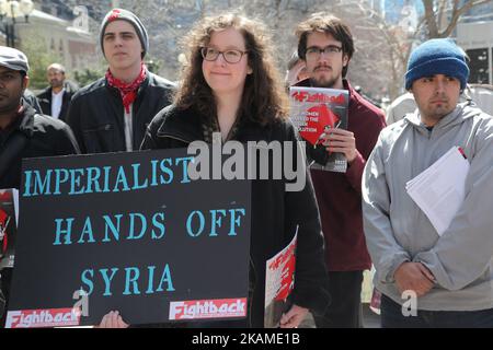 Woman tient un panneau disant « des mains impérialistes sur la Syrie » lors d'une protestation contre la décision du président américain Donald Trump de lancer des frappes aériennes contre la Syrie sur 8 avril 2017 à Toronto, Ontario Canada. Des manifestants se sont rassemblés devant le consulat américain de Toronto pour dénoncer les frappes aériennes de cette semaine contre le régime syrien. Les États-Unis ont lancé une frappe de missiles contre la Syrie pour la première fois depuis le début de la guerre civile, visant une base aérienne dans la petite ville d'Idlib à partir de laquelle les États-Unis revendiqueront cette semaine l'attaque d'armes chimiques contre des civils lancée par le régime de Bachar el-Assad. (Photo Banque D'Images