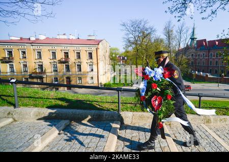 Un membre de la police municipale porte une couronne au sarcophage où le président polonais Lech Kaczynski et sa femme ont été mis en place, le jour où la Pologne a commémoré le 7th anniversaire de la catastrophe de Smolensk. Dans les premières heures du matin, à 10 avril 2010, un avion tu-154M s'est écrasé à Smolensk (Russie) à 1km km de la piste par temps brumeux, tuant les 96 passagers à bord, y compris le président polonais Lech Kaczynski et son épouse, l'ancien président Ryszard Kaczorowski, L'ensemble du commandement général de l'armée, le chef de l'état-major général polonais et d'autres hauts responsables politiques Banque D'Images