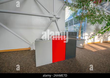 Trois poubelles sur un plancher de granit brun à l'intérieur d'un bâtiment à Tucson, Arizona. Bacs avec bac de recyclage rouge au milieu avec cadre en acier et bon de commande Banque D'Images