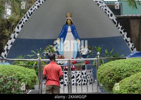 Un homme prie à Mary Grotto à l'église St Leo, Ikeja, Lagos. Des membres de l'Église catholique Sainte-Léo, Ikaja à Lagos au Nigéria, dramatisent la Station de la Croix, la souffrance et la mort de Jésus-Christ le Vendredi Saint, 14 avril 2017. (Photo par Adekunle Ajayi/NurPhoto) *** Veuillez utiliser le crédit du champ de crédit *** Banque D'Images