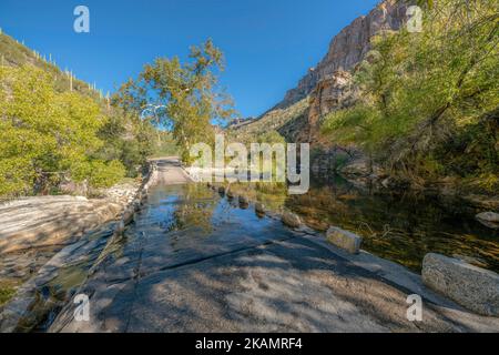 Le ruisseau Sabino s'écoulant sur le pont en béton du parc national de Sabino Canyon - Tucson, Arizona. Pont incliné sur une crique au milieu des montagnes du désert avec Banque D'Images