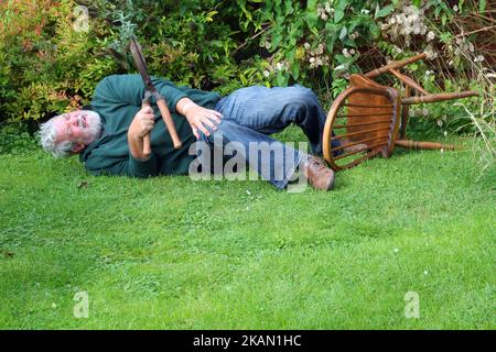 Homme de jardinage et a eu un accident. Tombé. Accident. Cisaille dans la main. Vieil homme blessé. Banque D'Images