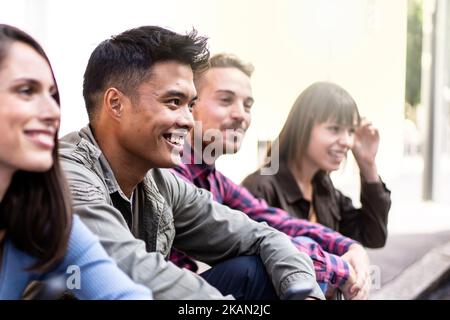Groupe de personnes multiculturel sans smartphone dans la cour de l'université - heureux amis du millénaire s'amuser ensemble assis dans la rue - Banque D'Images