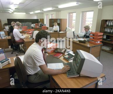 1989, historique, bureau ouvert, hommes et femmes travaillant à des bureaux, certains au téléphone, Angleterre, Royaume-Uni utilisant des consoles d'ordinateur ou des PC de l'époque. C'est au début de 80s, quand IBM a lancé son PC, que le marché des ordinateurs personnels de bureau de petite taille a vraiment commencé. Banque D'Images