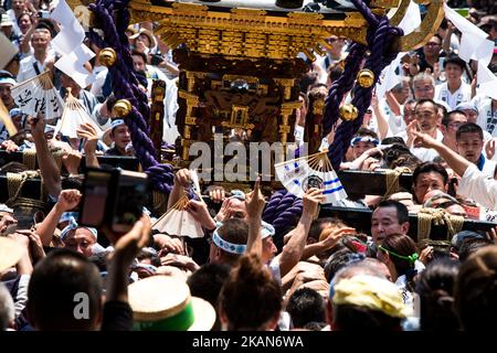 Les habitants d'Asakusa s'unissent pour porter un 'Mikoshi' (sanctuaires portables) pendant qu'ils chantent ensemble pendant le festival de Sanja devant le temple Senso-ji à Asakusa, Tokyo sur 20 mai 2017. Ces mikoshi sont transportés dans les rues d'Asakusa pour apporter chance, bénédictions et prospérité à la région et à ses habitants. (Photo de Richard Atrero de Guzman/NurPhoto) *** Veuillez utiliser le crédit du champ de crédit *** Banque D'Images