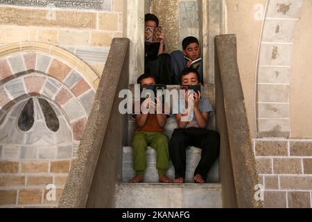 Les enfants palestiniens ont lu des copies du Coran, le livre le plus sacré de l'Islam, le premier jour de jeûne dans le mois sacré musulman du Ramadan, à la mosquée al-Omari de la ville de Gaza, sur 27 mai 2017. Plus de 1,5 milliards de musulmans dans le monde marqueront le mois, au cours duquel les croyants s'abstiendront de manger, de boire et de fumer de l'aube au coucher du soleil. (Photo de Majdi Fathi/NurPhoto) *** Veuillez utiliser le crédit du champ de crédit *** Banque D'Images