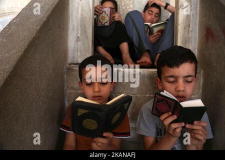 Les enfants palestiniens ont lu des copies du Coran, le livre le plus sacré de l'Islam, le premier jour de jeûne dans le mois sacré musulman du Ramadan, à la mosquée al-Omari de la ville de Gaza, sur 27 mai 2017. Plus de 1,5 milliards de musulmans dans le monde marqueront le mois, au cours duquel les croyants s'abstiendront de manger, de boire et de fumer de l'aube au coucher du soleil. (Photo de Majdi Fathi/NurPhoto) *** Veuillez utiliser le crédit du champ de crédit *** Banque D'Images