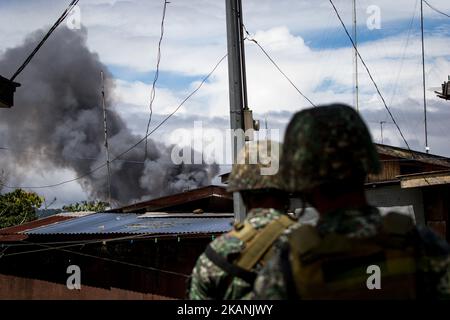 Les marines des Philippines regardent la fumée à la suite d'une frappe aérienne de l'armée de l'air philippine à Marawi, dans le sud des Philippines, sur 9 juin 2017. Des avions militaires philippins ont tiré des roquettes vendredi sur des positions militantes alors que des soldats se battaient pour combattre le contrôle de la ville du sud contre des hommes armés liés au groupe de l'État islamique. (Photo de Richard Atrero de Guzman/NurPhoto) *** Veuillez utiliser le crédit du champ de crédit *** Banque D'Images