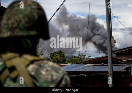 Les marines des Philippines regardent la fumée à la suite d'une frappe aérienne de l'armée de l'air philippine à Marawi, dans le sud des Philippines, sur 9 juin 2017. Des avions militaires philippins ont tiré des roquettes vendredi sur des positions militantes alors que des soldats se battaient pour combattre le contrôle de la ville du sud contre des hommes armés liés au groupe de l'État islamique. (Photo de Richard Atrero de Guzman/NurPhoto) *** Veuillez utiliser le crédit du champ de crédit *** Banque D'Images