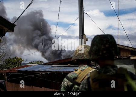 Les marines des Philippines regardent la fumée à la suite d'une frappe aérienne de l'armée de l'air philippine à Marawi, dans le sud des Philippines, sur 9 juin 2017. Des avions militaires philippins ont tiré des roquettes vendredi sur des positions militantes alors que des soldats se battaient pour combattre le contrôle de la ville du sud contre des hommes armés liés au groupe de l'État islamique. (Photo de Richard Atrero de Guzman/NurPhoto) *** Veuillez utiliser le crédit du champ de crédit *** Banque D'Images